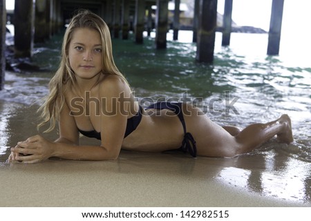 girl in bikini under an ocean pier