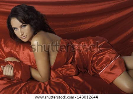 beautiful woman on red satin sheets