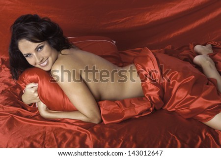 beautiful woman on red satin sheets