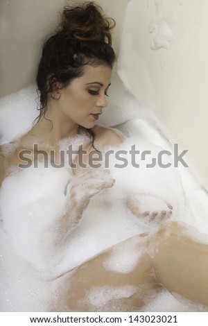 beautiful brunette girl taking a bubble bath