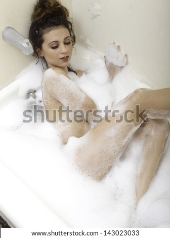 beautiful brunette girl taking a bubble bath