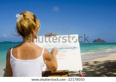 A female artist painting on the beach in Hawaii