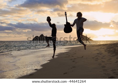 silhouette of twin brothers with drum and guitar leaping in the air at sunrise on a hawaii beach