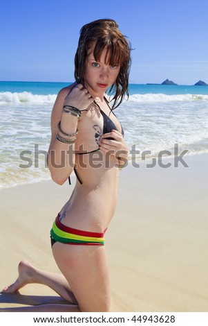 stock photo : young woman on a beach showing her breast tattoo