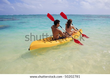 young couple kayaking in hawaii