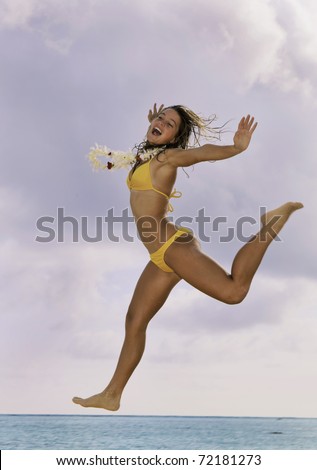 hawaii beaches girls. stock photo : pretty girl in bikini with lei jumping at a hawaii beach