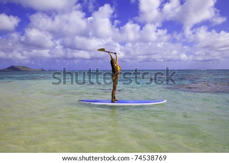 young japanese woman in a bikini with her paddle board in the ocean in Hawaii