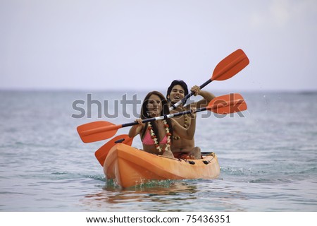 young asian couple in their kayak in hawaii