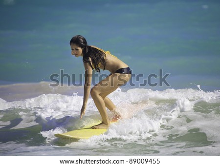 beautiful brunette in bikini surfing at Kailua Beach, Hawaii