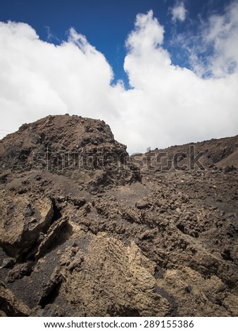 Old Lava flow on Mt. Etna with clouds behind it.
