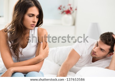 Portrait Of Unhappy Young Heterosexual Couple In Bedroom