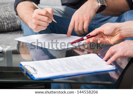 Hands of people signed the document, sitting at the desk