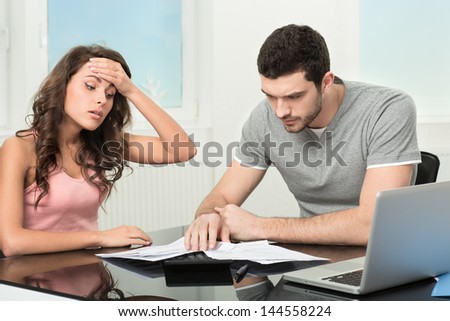 Couple, Man angry and upset after looking at credit card statement.