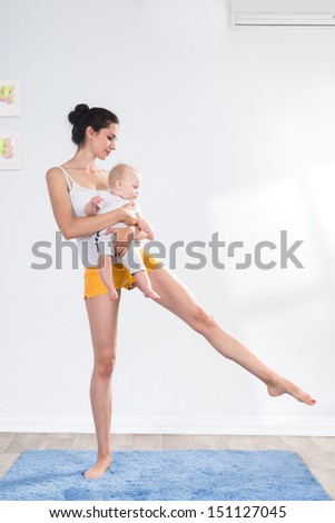 young mother does physical fitness exercises together with her baby