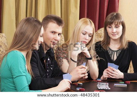 Party (three girls and one young man) playing cards