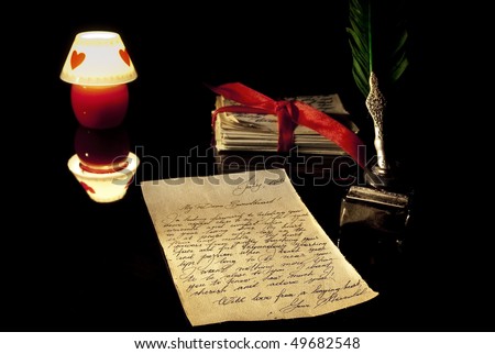 Old love letter, antique quill, stack of letters tied with a red ribbon and romantic candle