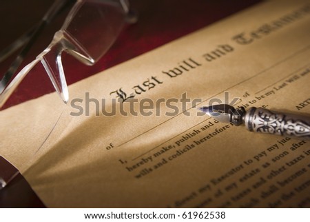 Old-fashioned paper with text of Last will and focus on antique quill
