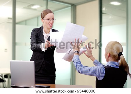 Angry businesswoman throwing papers in her partner
