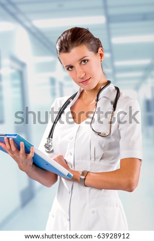young  brunette in white medical gown and a stethoscope and file folder in an hospital