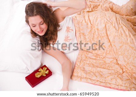 Portrait of young woman that wake up and see gift at bedroom
