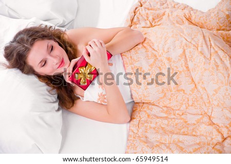Portrait of young woman that wake up and see gift at bedroom