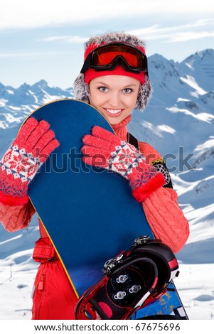 young snowboarder girl in winter clothes with snowboard in her hands