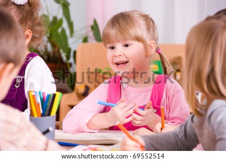 preschoolers playing and painting with colored pencils