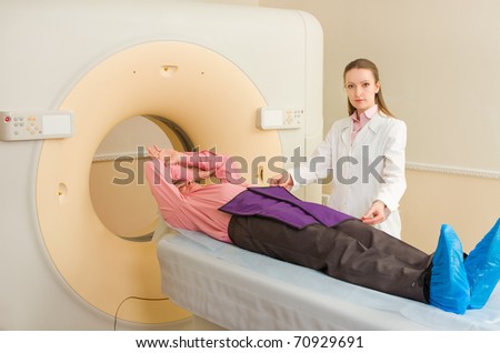 Woman Technologist testing patient with CT Scan Machine in hospital