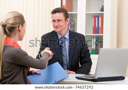 hands shake between two successful business people: man and woman at office place