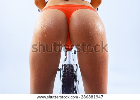 Buttocks of young woman with waterdrops at skin