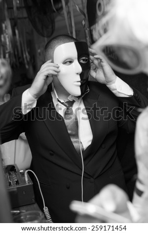 young man with black and  white mask and suite