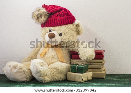 Cute teddy bear with christmas gift and red hat