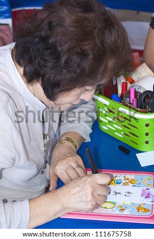 RIO DE JANEIRO - AUG 18: japanese lady writes in a paper ribbon  at the japanese party in Rio de Janeiro. August 18, 2012 in Rio de Janeiro, Brazil