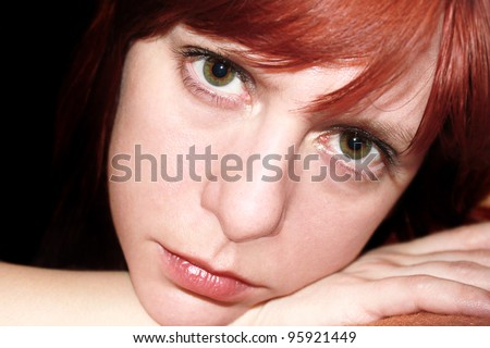Portrait of beautiful woman on black background with sad expression on her face