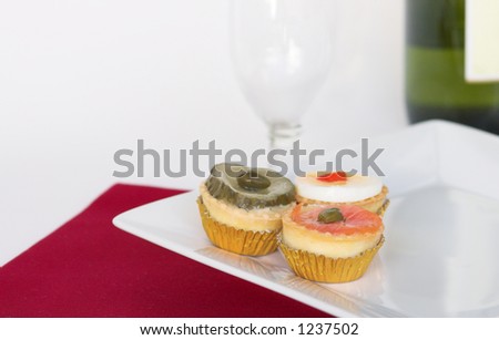 Canapes on a porcelain plate with vine and a glass