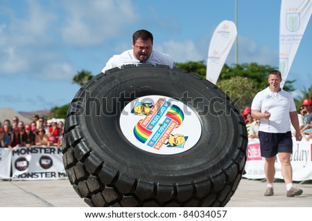 CANARY ISLANDS - SEPTEMBER 03: Jimmy Laureys (l) from Belgium lifting and rolling a wheel (weights 400kg) during Strongman Champions League in Las Palmas September 03, 2011 in Canary Islands, Spain