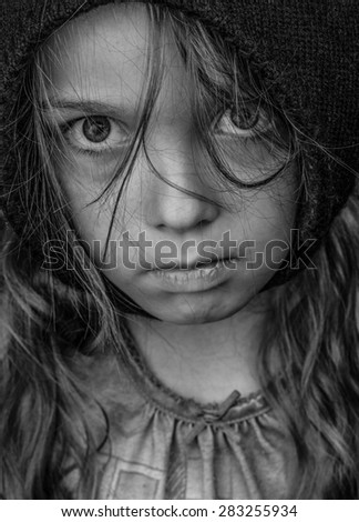 Head and shoulders portrait of a waif like female child (7years old), emotional expression