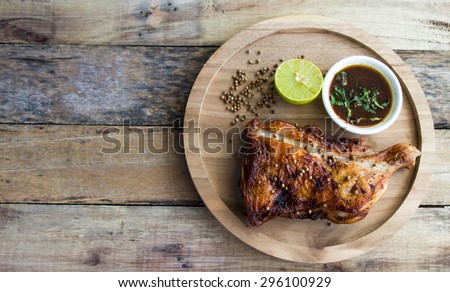Grilled chicken and lemon on old wooden floor,a particular focus.