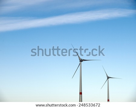 Two windmills before a blue sky with some clouds
