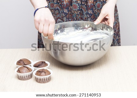 Woman cooking cream for cupcakes