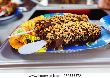 Tasty bananas covered by chocolate and nuts are prepared for a holiday lunch.