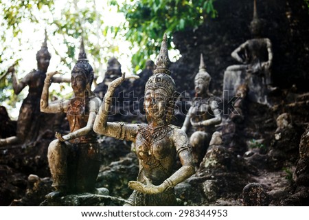 Row of old statues in secret buddhist garden. Concept of mysterious place for relaxation and meditation.