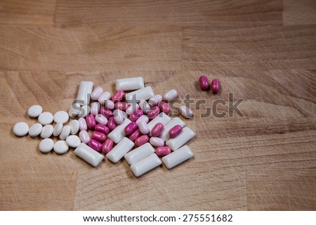 Pink and white mints for fresh breath on a wooden background
