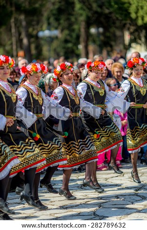 RAZLOG, BULGARIA - APRIL 13, 2015: Female Bulgarian folklore dancers playing a round dance during the traditional folklore festival \