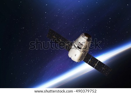 Cargo spaceship in the space and earth on the background. Elements of earth on this image furnished by NASA. Astronomy and outer space conception. Distant galaxies and space dream. Cosmos. Spacecraft