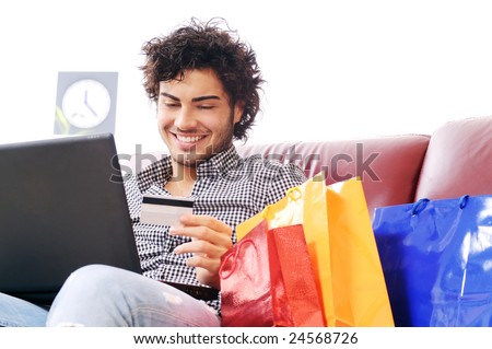 a young man  using his credit card to purchase over the internet, happiness and amazement