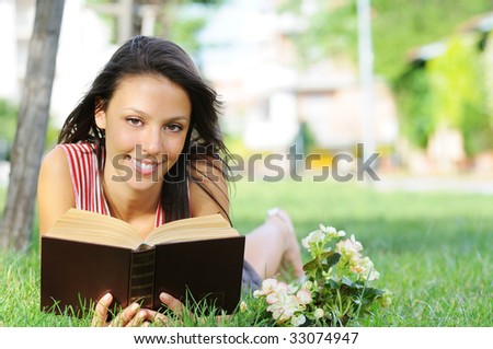 young woman with book, reading in green park