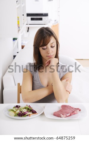 young woman eating salad and meat, concept of choosing