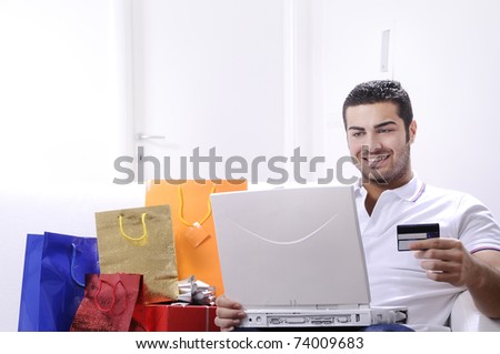 happy shopping on line; young man buying with credit card on internet