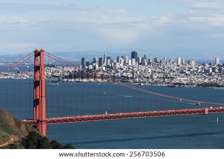 View on Golden Gate bridge and San Francisco looking south with blue water and sky partially obscured by clouds